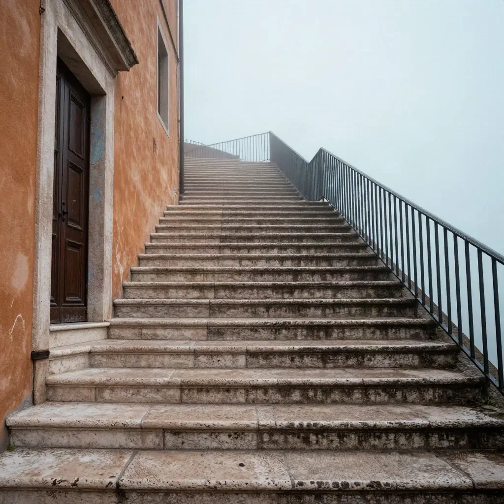 Scalinata in pietra di Orvieto con muro ocra, ringhiera in ferro e nebbia del mattino.